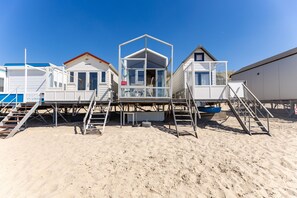 A row of beachside mobile homes with external staircases leading to the beach. - Slaapstrandhuisje - Strand Dishoek 37 I Dishoek (Vlissingen)