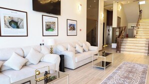 A modern living room with a sofa set, coffee table, and a rug. - Hadaj Town Apartment Hotel (Al-'Ula)