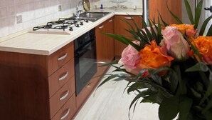 Eine moderne Küche mit Holzschränken, einem Gasherd und einem eingebauten Backofen.