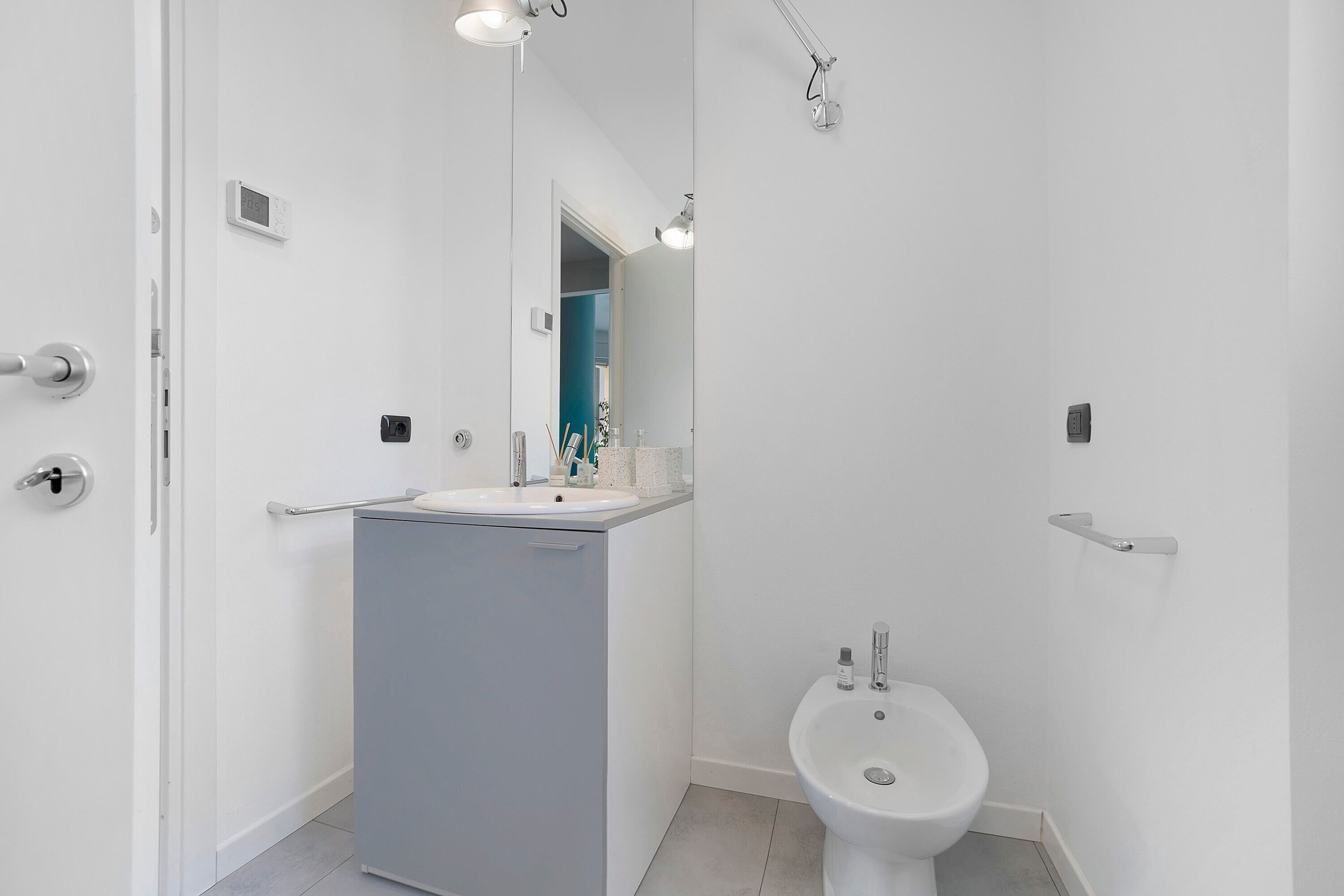 Une salle de bain moderne avec un lavabo, un bidet et un miroir.
