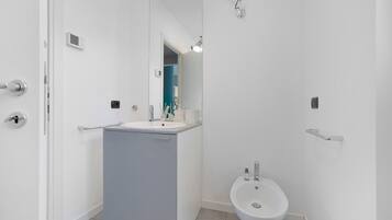 Une salle de bain moderne avec un lavabo, un bidet et un miroir.