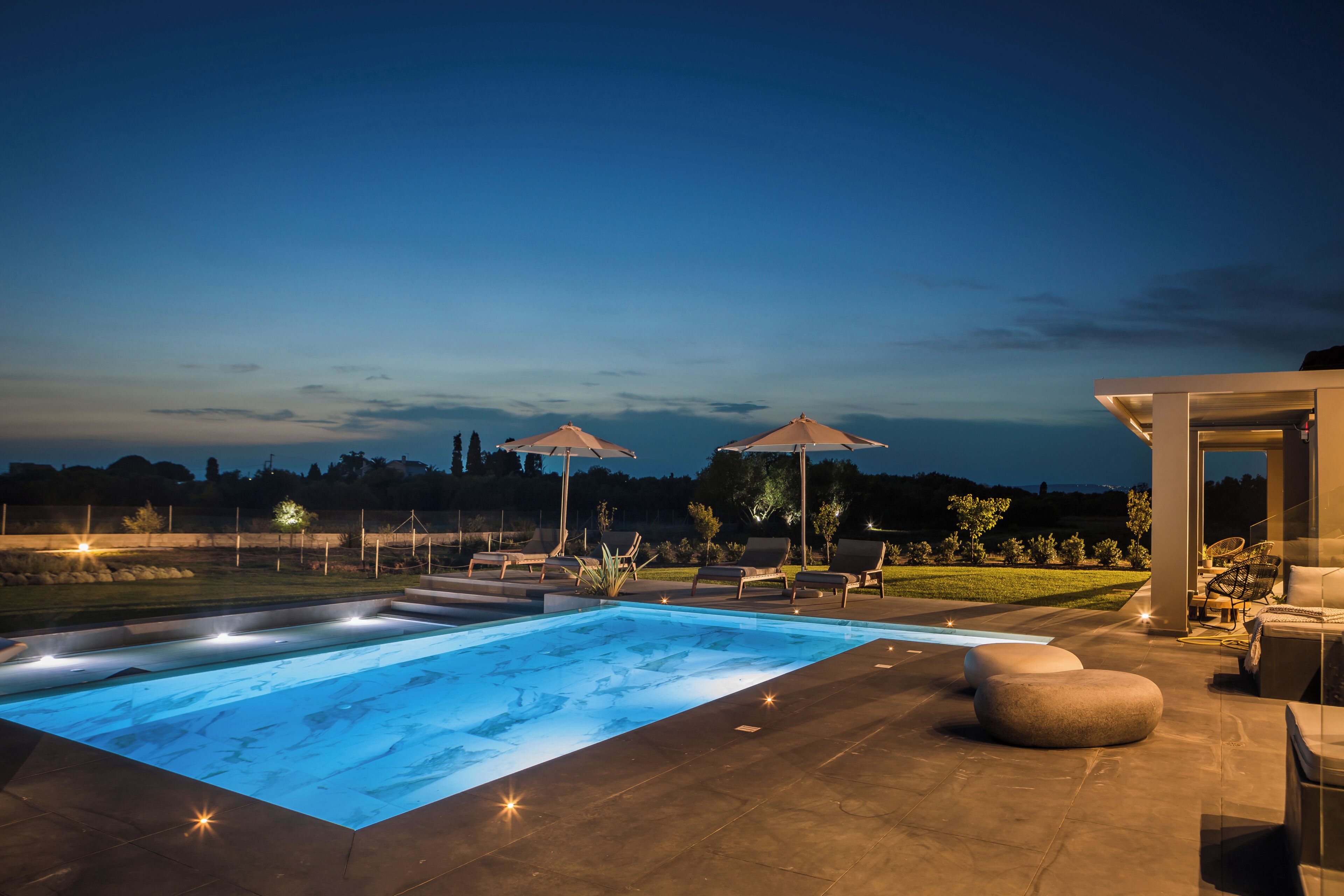 Una piscina con vistas al paisaje, mobiliario exterior y una zona cubierta.
