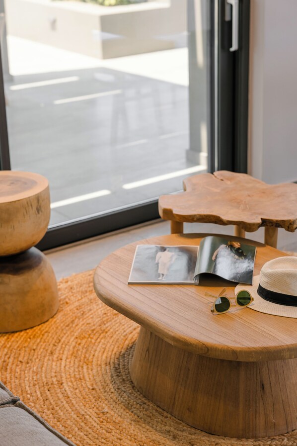 Una mesa de madera con revistas, gafas de sol y un sombrero.