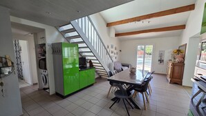 A spacious kitchen with a dining area, a staircase, and a view to the outside. - Villa with private pool - 7 guests (Jard-sur-Mer)