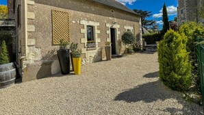 A stone building with a gravel courtyard, a small window, and a door. - Historic charm cottage - 3 guests (Sazilly)