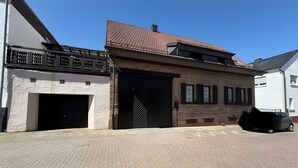A building with a garage door, a brick facade, and a tiled roof. - Spacious & Comfortable House – Perfect for Workers or Holiday Guests (Orbis)