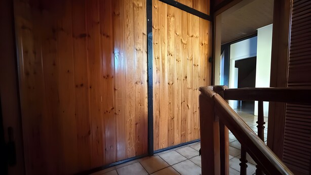 A wooden interior with a tiled floor, a staircase, and a door. - Spacious & Comfortable House – Perfect for Workers or Holiday Guests (Orbis)