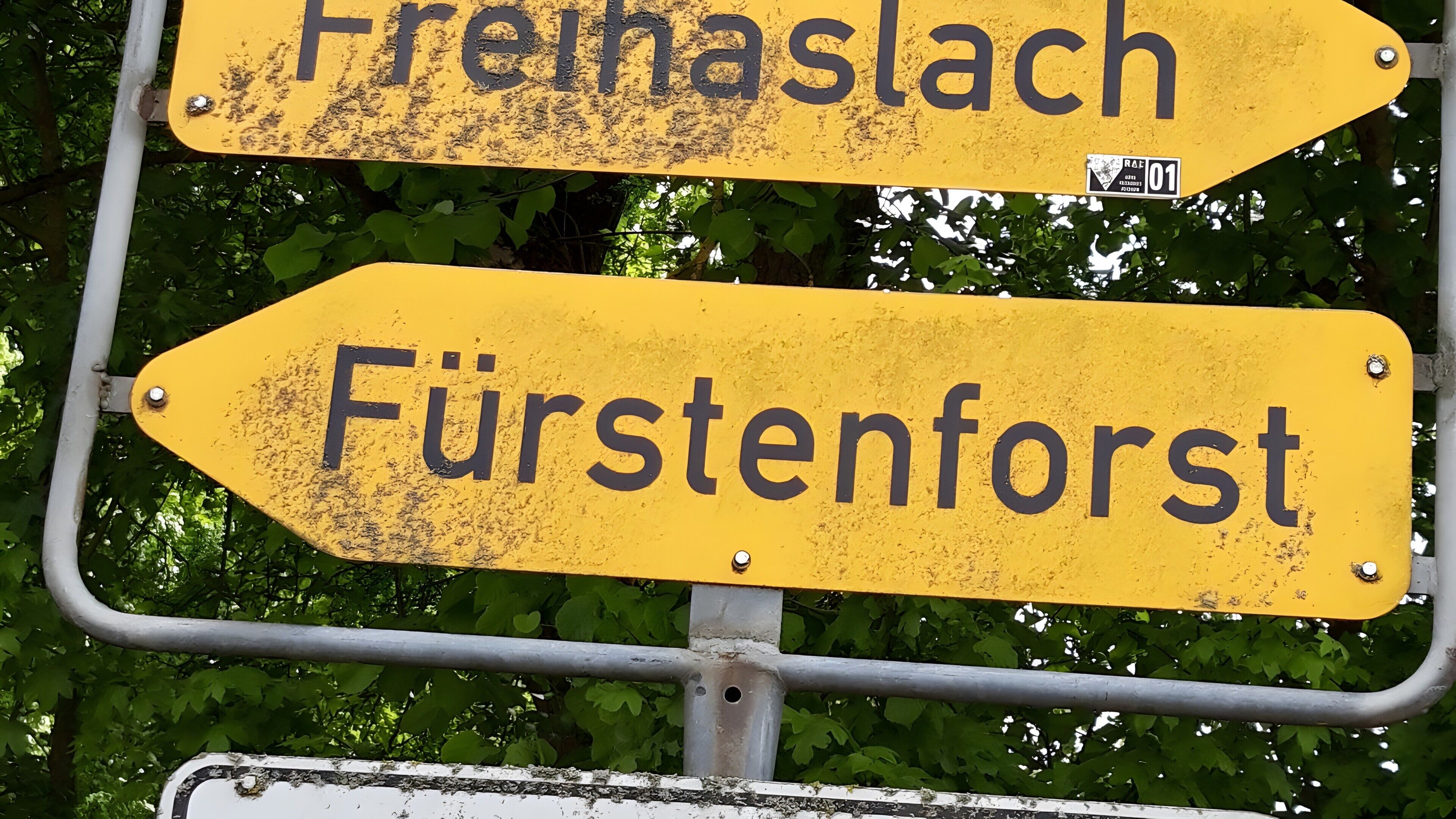 Deux panneaux de signalisation directionnels fixés sur un poteau métallique, l’un indiquant la direction gauche et l’autre la direction droite.