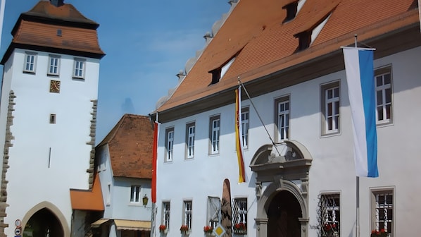 A historic building with a tower, arched windows, and a flagpole.