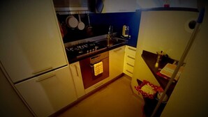 A compact kitchen with a stove, oven, and a sink. - Attic Boutique May (Bergamo)