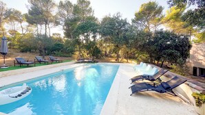 Ein Swimmingpool mit Liegestühlen und Sonnenschirm.