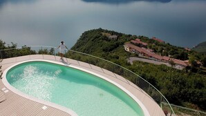 Piscina com vista para um lago e montanhas.