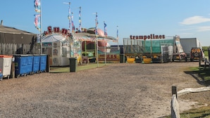 Uma feira com um carrossel e uma área de trampolins.