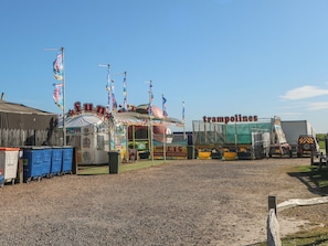 A fairground with a carousel and a trampoline area.