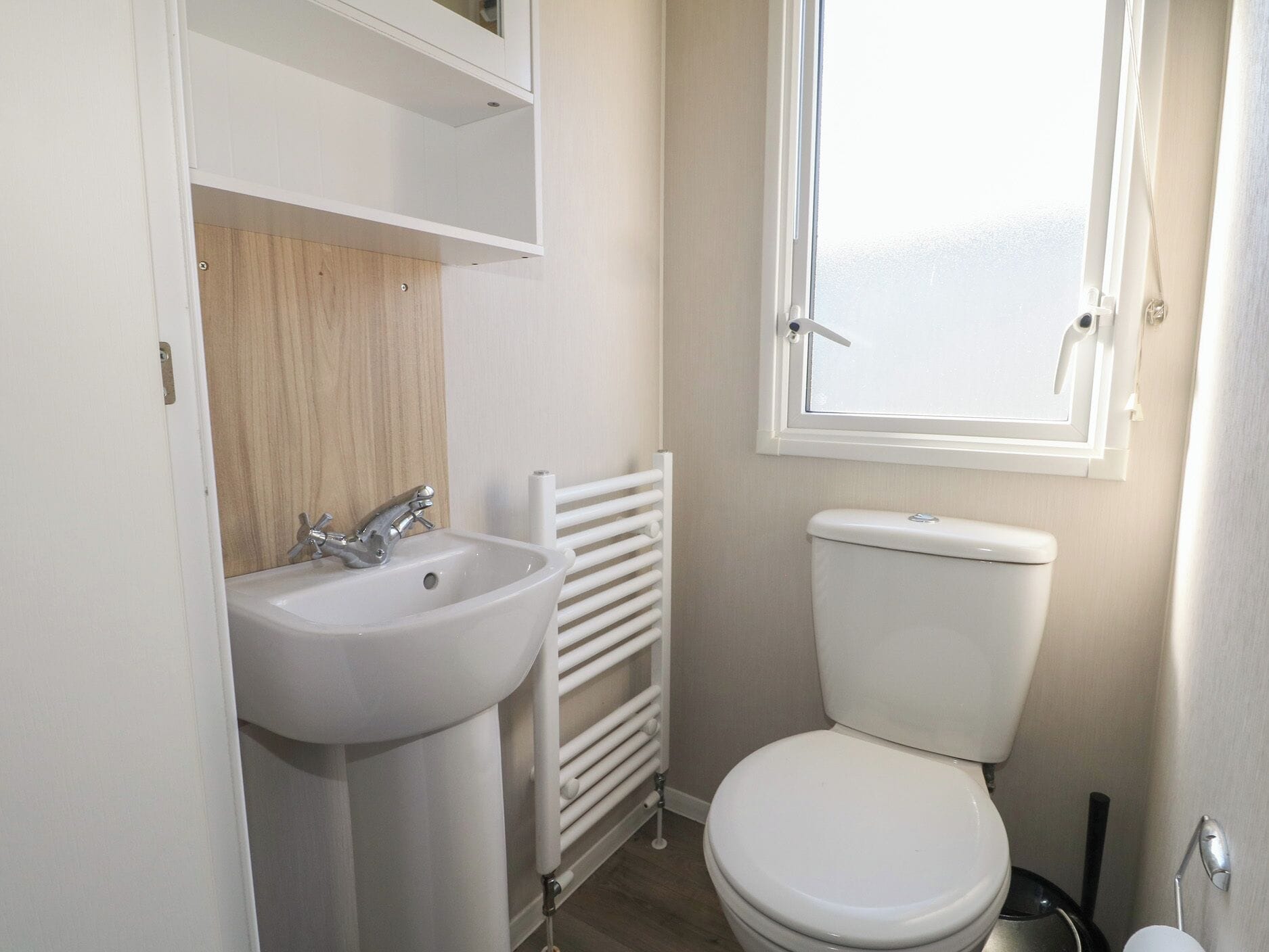 Un baño con lavamanos, inodoro y ventana.