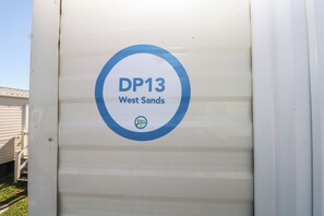 Un panneau indiquant « DP13 West Sands » et comportant un logo.
