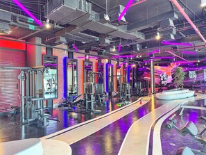 A gym with various exercise equipment, mirrored walls, and a polished floor. - PVH - Al Jawhara - Charming Studio (Dubai)