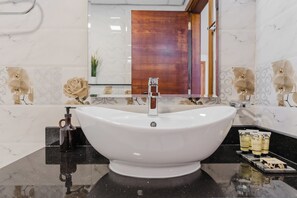 A bathroom with a white vessel sink, black countertop, and a mirror above. - PVH - Al Jawhara - Charming Studio (Dubai)