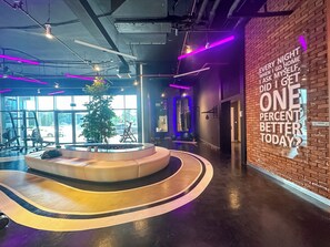 A gym with exercise equipment, a circular seating area, and a motivational quote on the wall. - PVH - Al Jawhara - Charming Studio (Dubai)