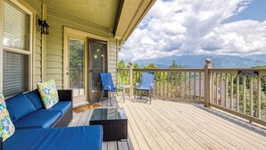 A covered porch with a sofa, chairs, and a view of mountains. - Amazing Gatlinburg Views - Briarcliff Subdivision, Hot Tub, Game Room, Sleeps 8 (Gatlinburg)