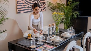 Una mesa de comedor dispuesta con vasos, platos y una revista.