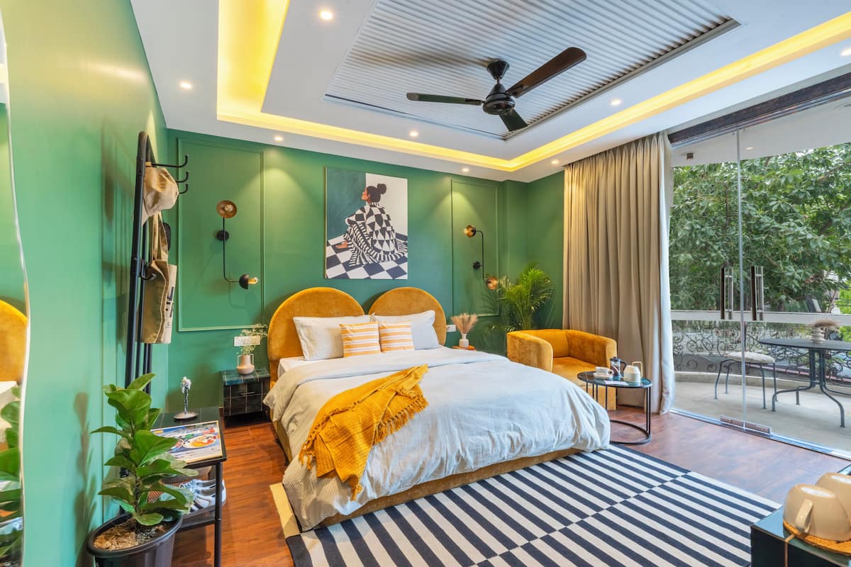 Quarto moderno com uma cama grande, ventoinha no teto, vista para o exterior e varanda.