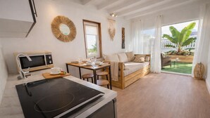 Una cocina moderna con estufa, microondas y comedor con mesa y sillas.