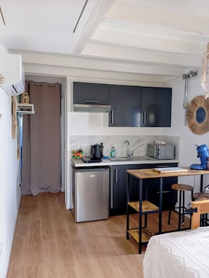 Eine kleine Küche mit Kühlschrank, Kaffeemaschine und Toaster.