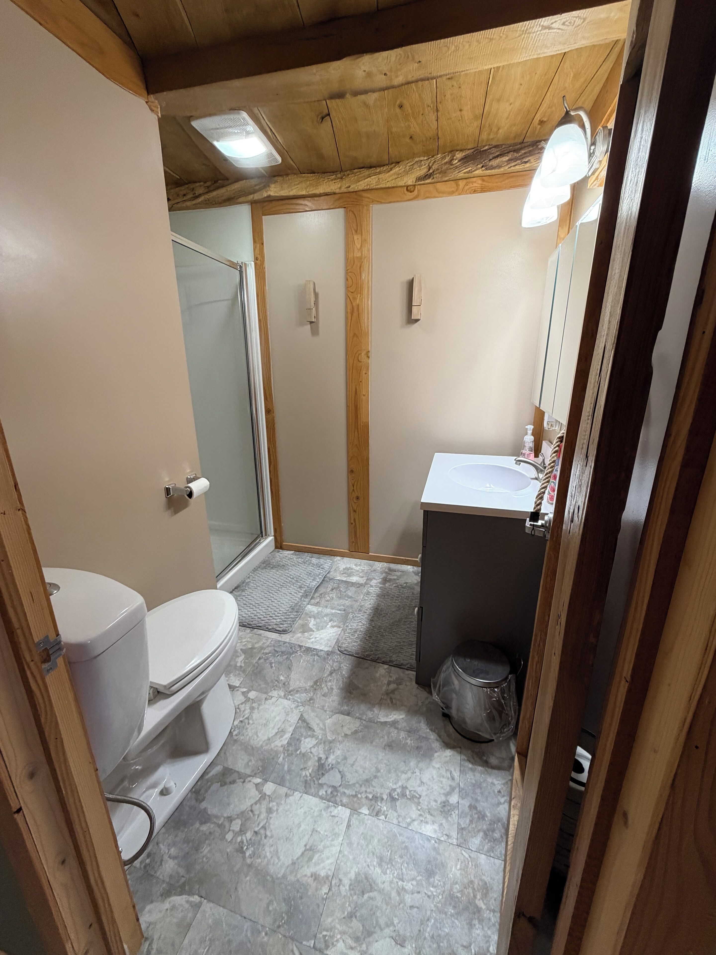 A small bathroom with a toilet, a shower, and a sink.