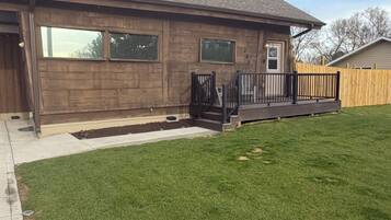 A single-story house with a front porch, a fenced yard, and a well-maintained lawn.