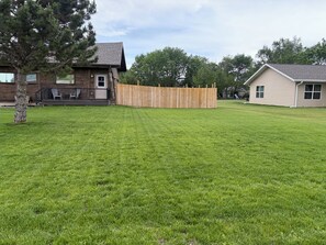 Il s’agit d’une propriété résidentielle dotée d’une pelouse bien entretenue, d’une terrasse en bois et d’une cour arrière clôturée.