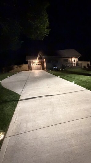 A driveway leading to a garage with a well-lit entrance.