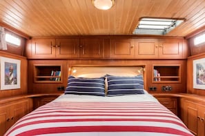 Una cabaña con cama, armarios de madera y tragaluz.