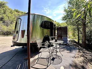 Une remorque équipée d’un espace patio couvert, comprenant une table et des chaises.