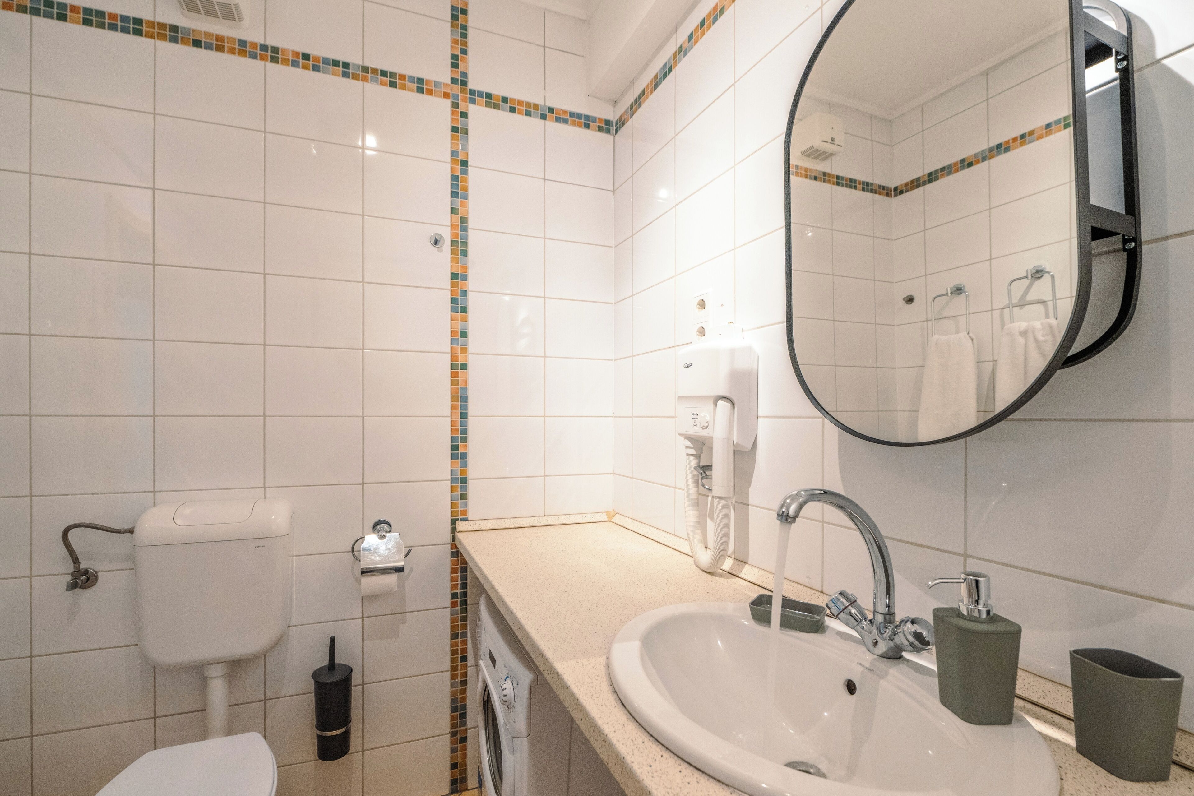 Ein Badezimmer mit Toilette, Waschbecken und Spiegel.