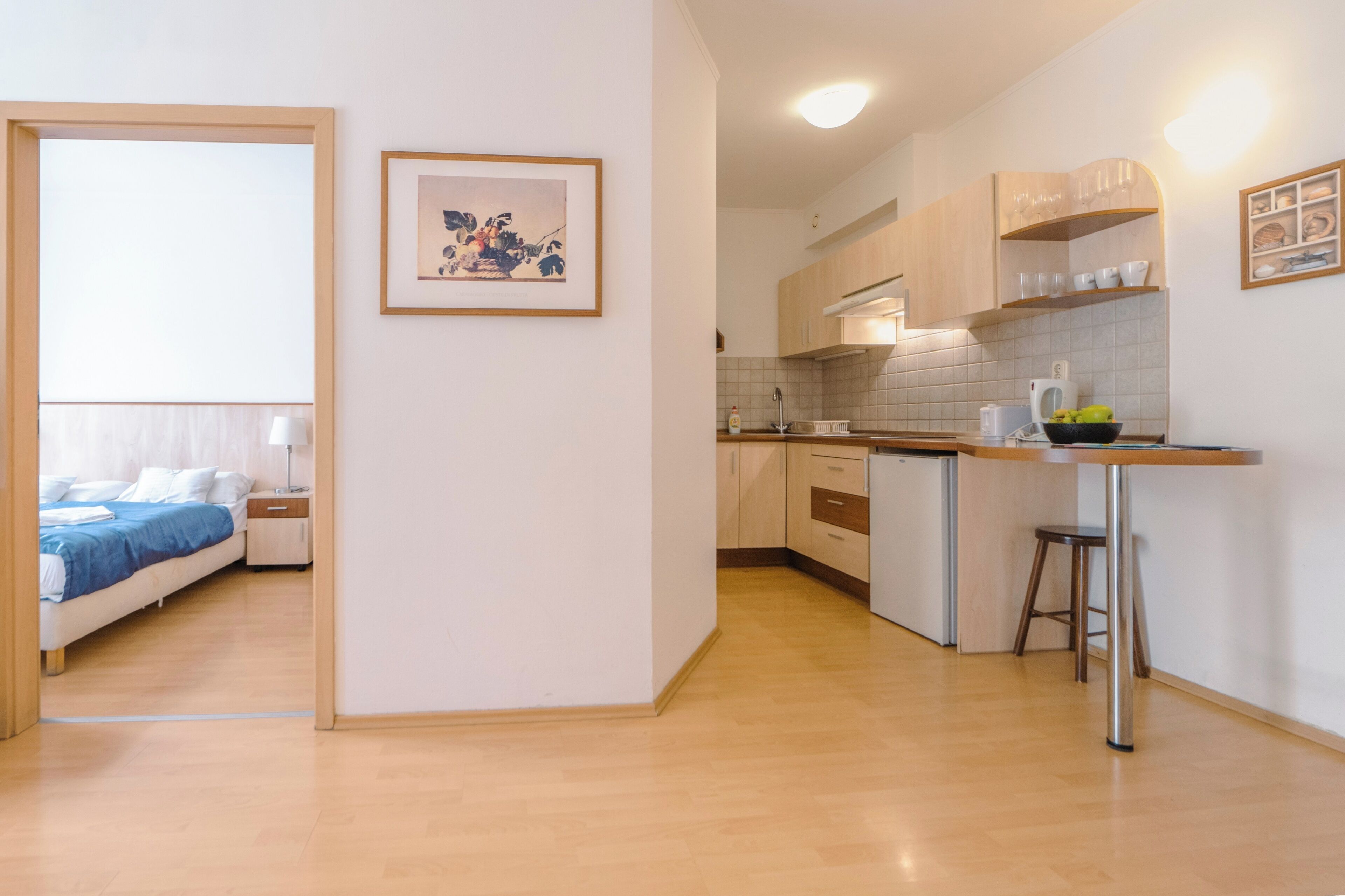 Un appartamento moderno con cucina, zona pranzo e camera da letto.