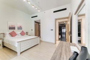 Ein modernes Schlafzimmer mit Bett, Nachttischen, Schreibtisch und Spiegel.