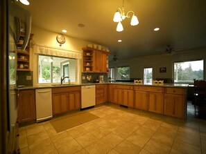 A kitchen with wooden cabinets, a dishwasher, and a large window.