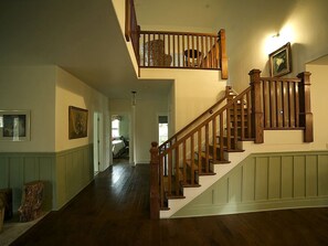 A wooden staircase with a handrail, a framed picture on the wall, and a door leading to another room. - Luxury Cabin Rental in the Cascade Mountains near Crater Lake, Southern Oregon (Prospect)