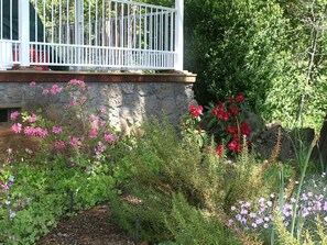 A garden with various flowers and a stone wall.