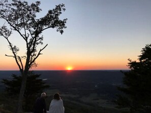 A sunset view from a high vantage point with two people observing.