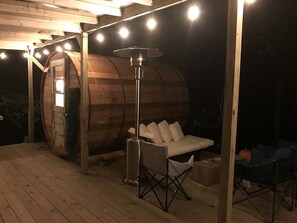 Eine Holzbaukonstruktion mit einem weißen Sofa und einer Metall-Tischlampe.