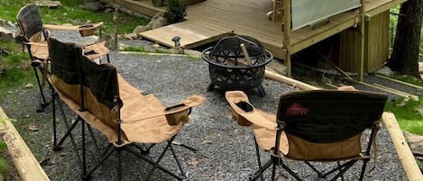 Un chalet rustique doté d’une terrasse, d’un espace salon extérieur et d’un foyer.