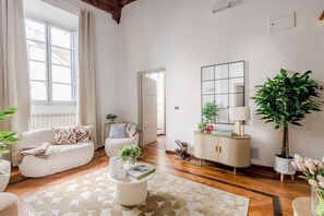 Ein Wohnzimmer mit einer Couch, einem Couchtisch, einem Schrank und einer großen Pflanze.