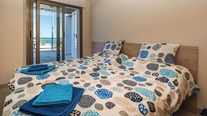 A bedroom with a bed, pillows, and a blue towel.
