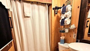 A wooden bathroom with a toilet, sink, and towel rack. - Romantic Creekside Cabin Retreat with Hot Tub, Fire Pit and Peaceful Forest Views in Sautee Nacoochee, Georgia (Sautee Nacoochee)