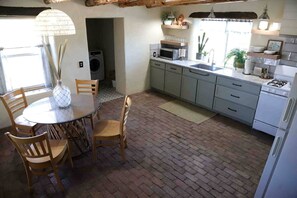 Una cocina con comedor, lavadora y estufa.