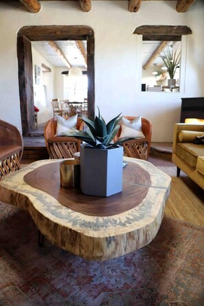 Una sala de estar con una mesa redonda, una planta en maceta y un sofá.