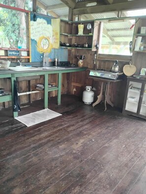 Une cuisine rustique avec des meubles en bois, une cuisinière à gaz et un évier.