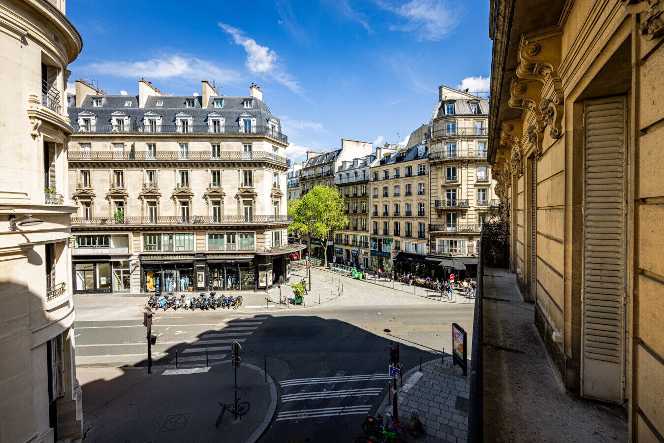 Une vue de rue avec des bâtiments, un arbre et un passage pour piétons.